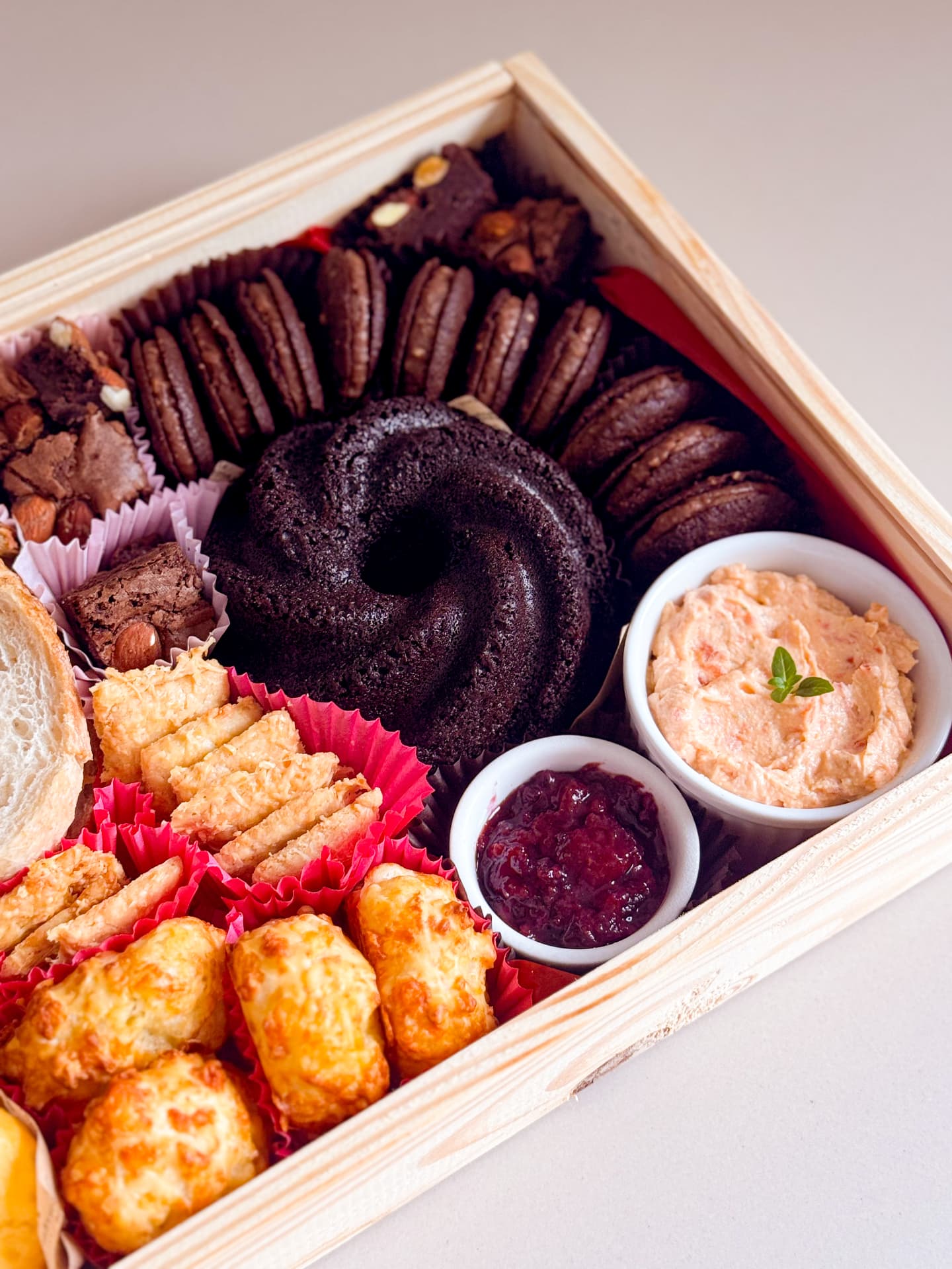 Detalhe da cesta Gio da manhã: mini bolo de chocolate, macarons, brownies e ramequins com geleia e patê