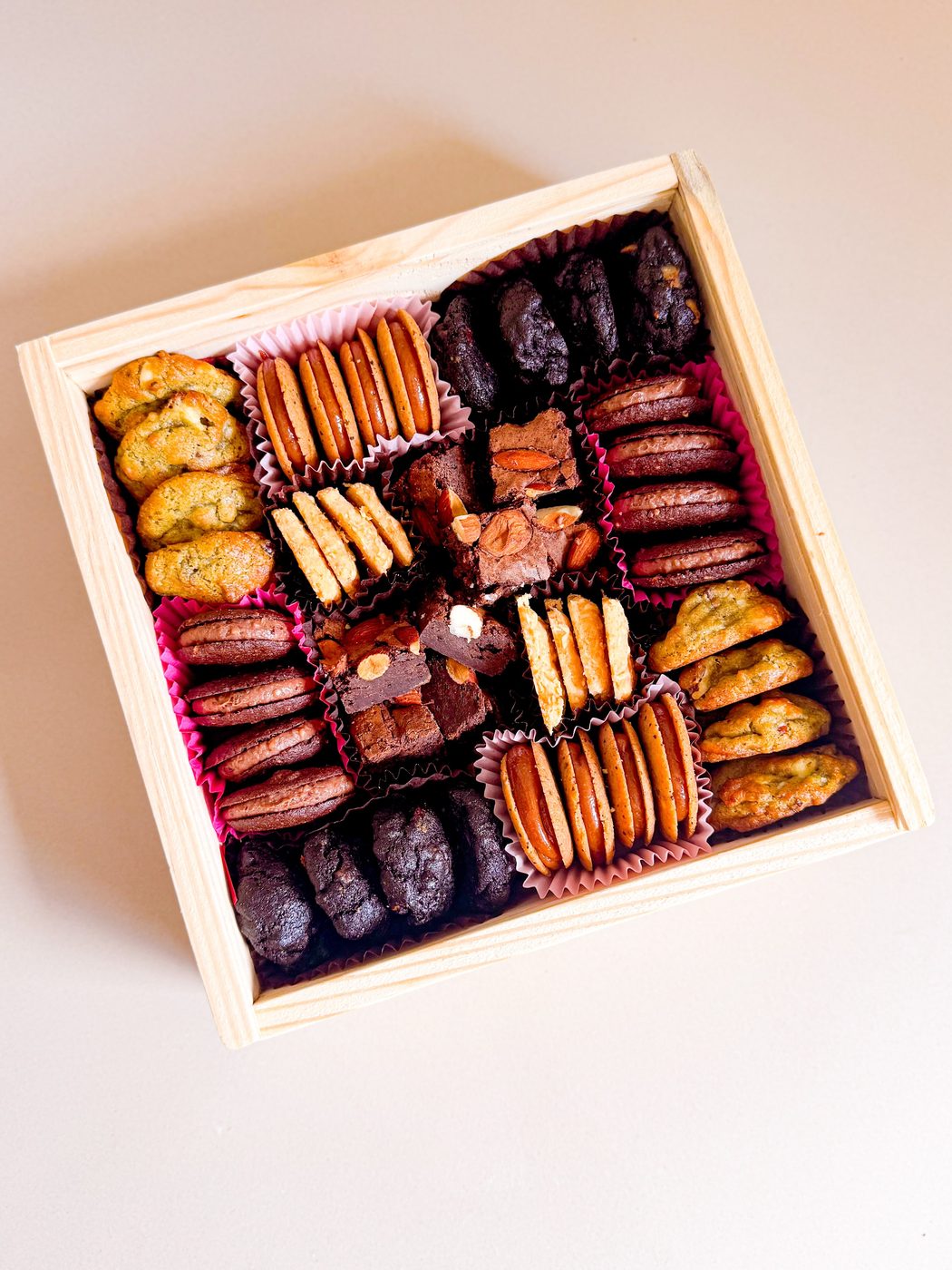 Caixa Deli Delicadezas vista de cima, cheia de biscoitos e brownies artesanais